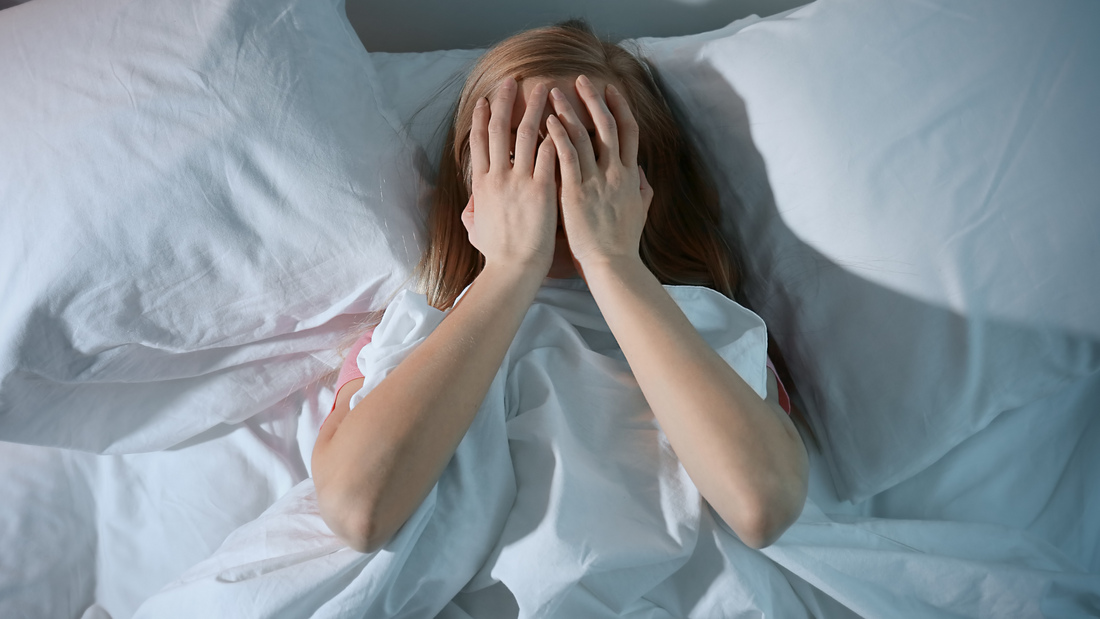 frustrated girl with hands over her face struggling with insomia